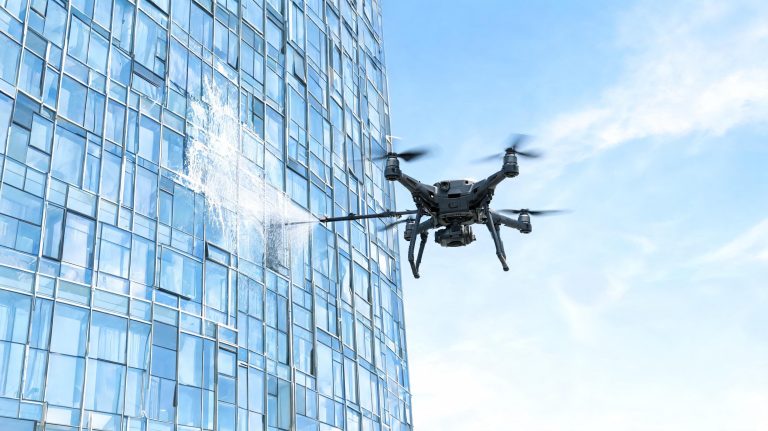 Drone de nettoyage intervenant sur des vitres en grande hauteur sur un bâtiment professionnel à Toulouse, avec pulvérisation contrôlée et sécurité renforcée